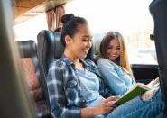 Younger women reading book on train